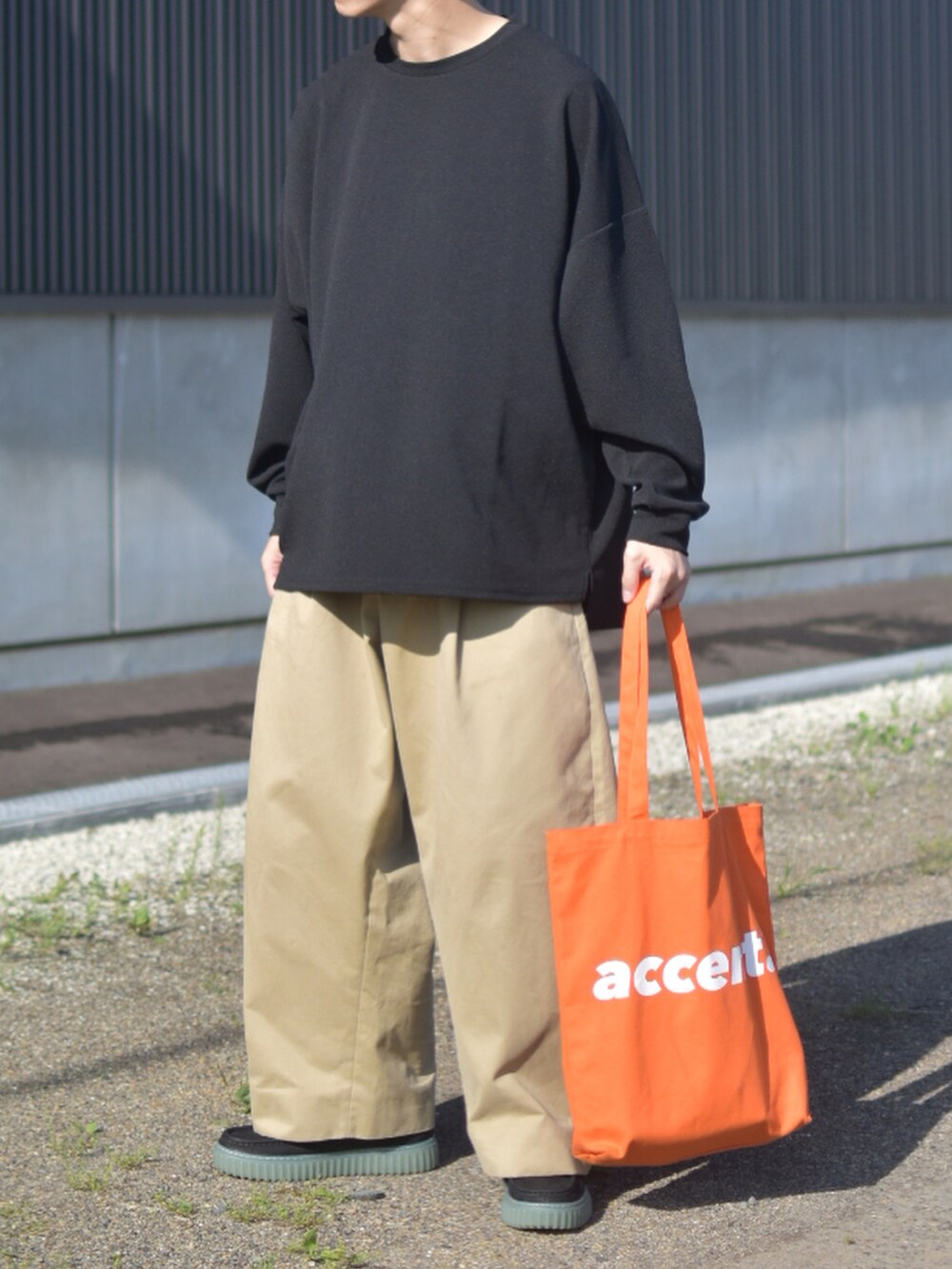ブラック系のTシャツ/カットソー、ベージュ系のその他パンツ、ブラック系のモカシン/デッキシューズを着用したメンズの秋コーディネートの3枚目の写真