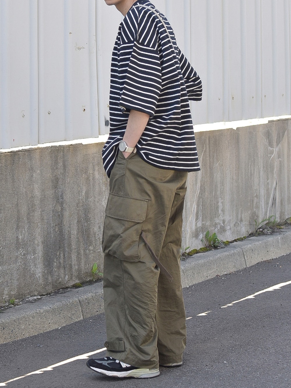 ブラック系のTシャツ/カットソー、グリーン系のカーゴパンツ、ブラック系のシューズを着用したメンズの夏コーディネートの4枚目の写真
