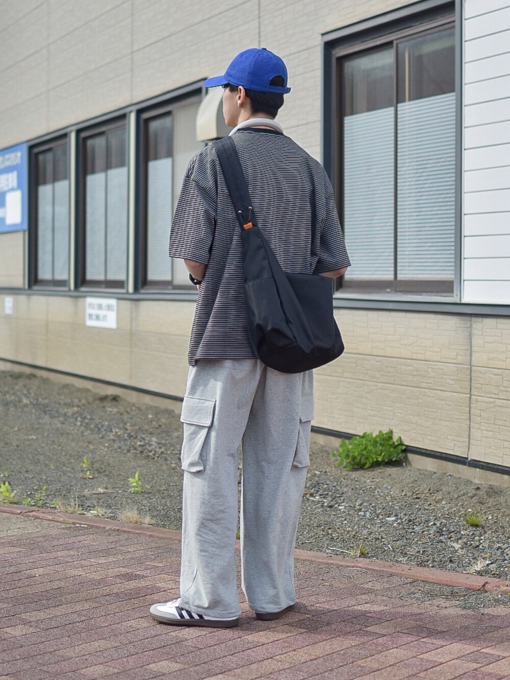 グレー系のTシャツ/カットソー、グレー系のスウェットパンツ、ホワイト系のスニーカーを着用したメンズの春コーディネートの3枚目の写真