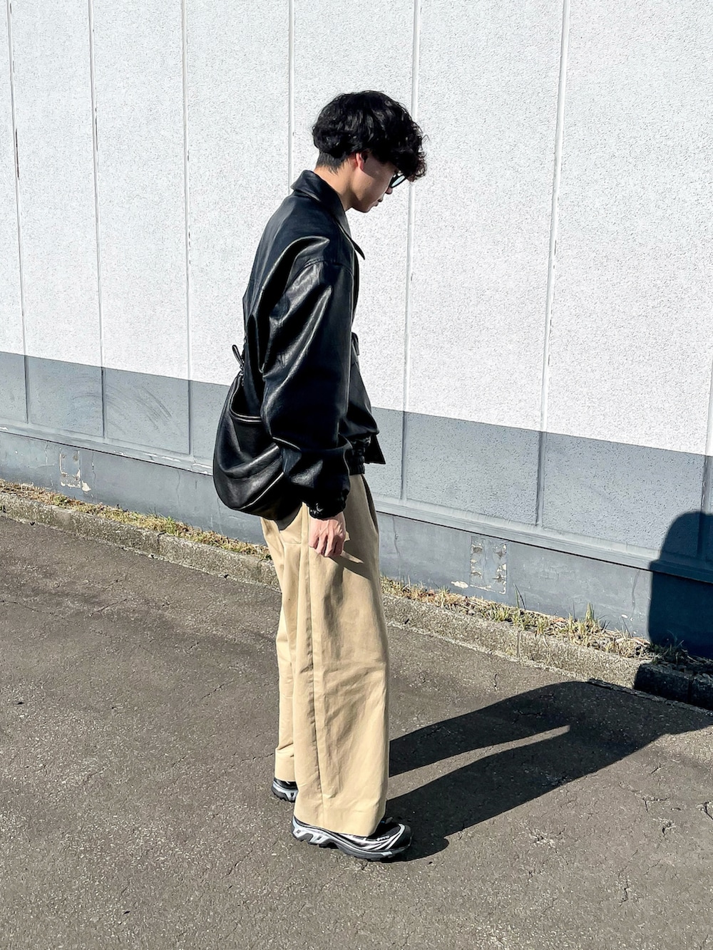 ブラック系のブルゾン、ブラック系のショルダーバッグ、ベージュ系のスウェットを着用したメンズの秋コーディネートの3枚目の写真