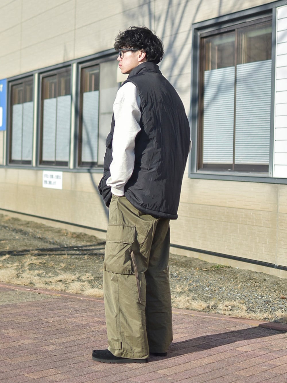 ブラック系のダウンベスト、グレー系のスウェット、グリーン系のカーゴパンツを着用したメンズの冬コーディネートの4枚目の写真