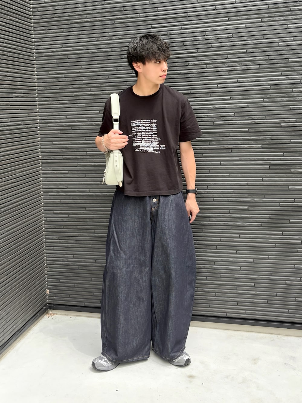 ブルー系のデニムパンツ、グレー系のスニーカー、ブラック系のTシャツ/カットソーを着用したメンズの夏コーディネートの2枚目の写真