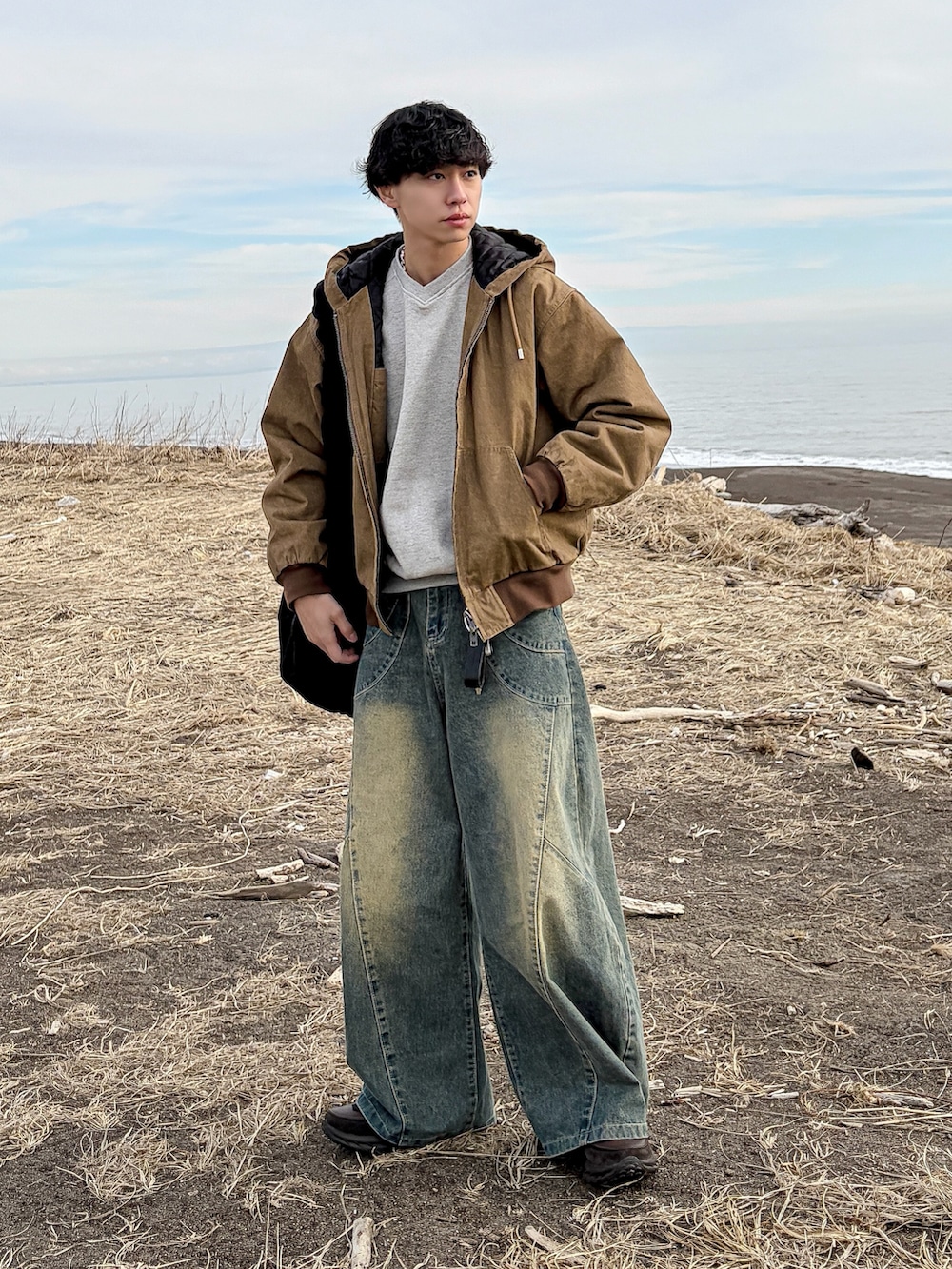 ブラウン系のその他アウター、ブルー系のデニムパンツ、グレー系のスウェットを着用したメンズの冬コーディネートの2枚目の写真