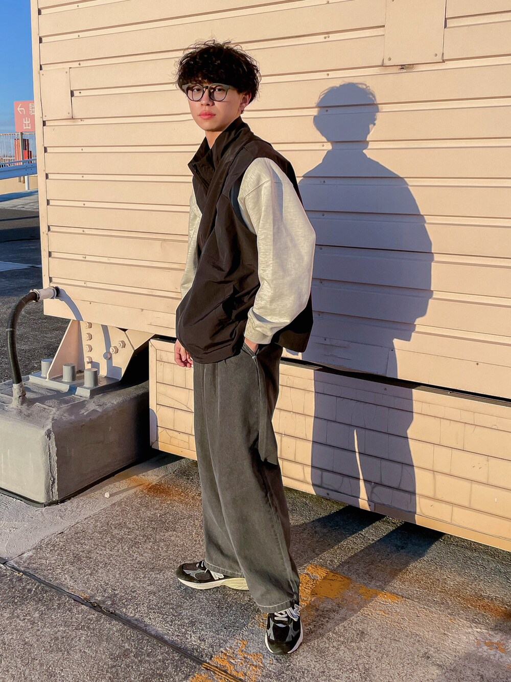 ブラック系のベスト、グレー系のスウェット、グレー系のデニムパンツを着用したメンズの冬コーディネートの3枚目の写真