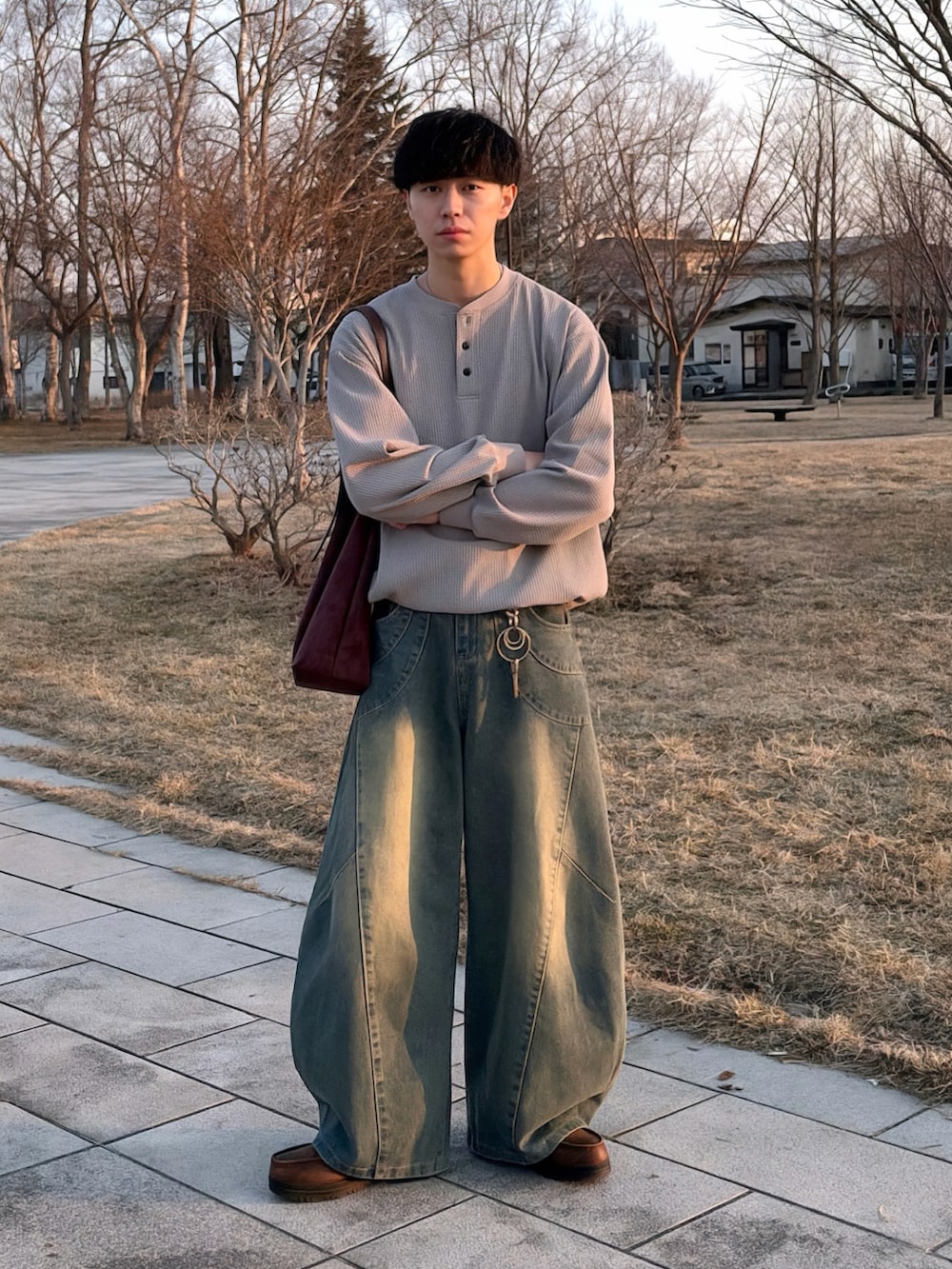 グレー系のTシャツ/カットソー、ブルー系のデニムパンツ、ブラウン系のショルダーバッグを着用したメンズの春コーディネートの2枚目の写真