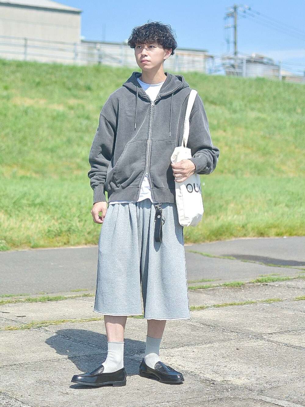 グレー系のパーカー、グレー系のスウェットパンツ、ホワイト系のトートバッグを着用したメンズの夏コーディネートの3枚目の写真