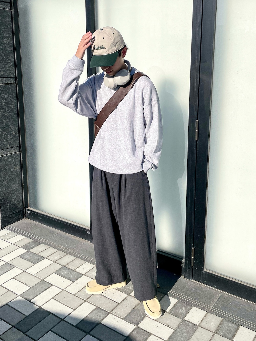 グレー系のスウェット、グレー系のスラックス、ベージュ系のモカシン/デッキシューズを着用したメンズの秋コーディネートの4枚目の写真