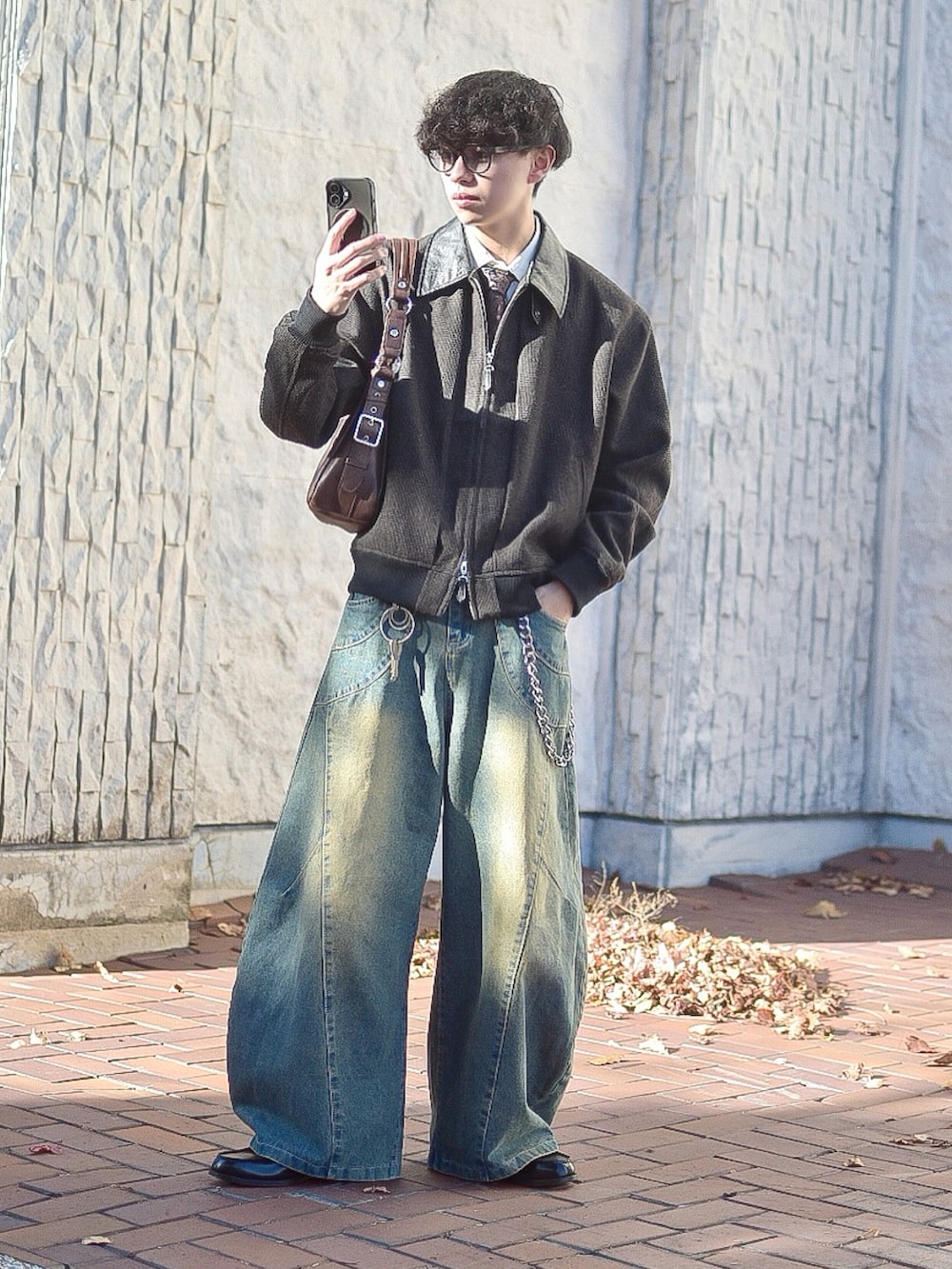 ブラウン系のブルゾン、ブルー系のデニムパンツ、ブラック系のローファーを着用したメンズの秋コーディネートの3枚目の写真