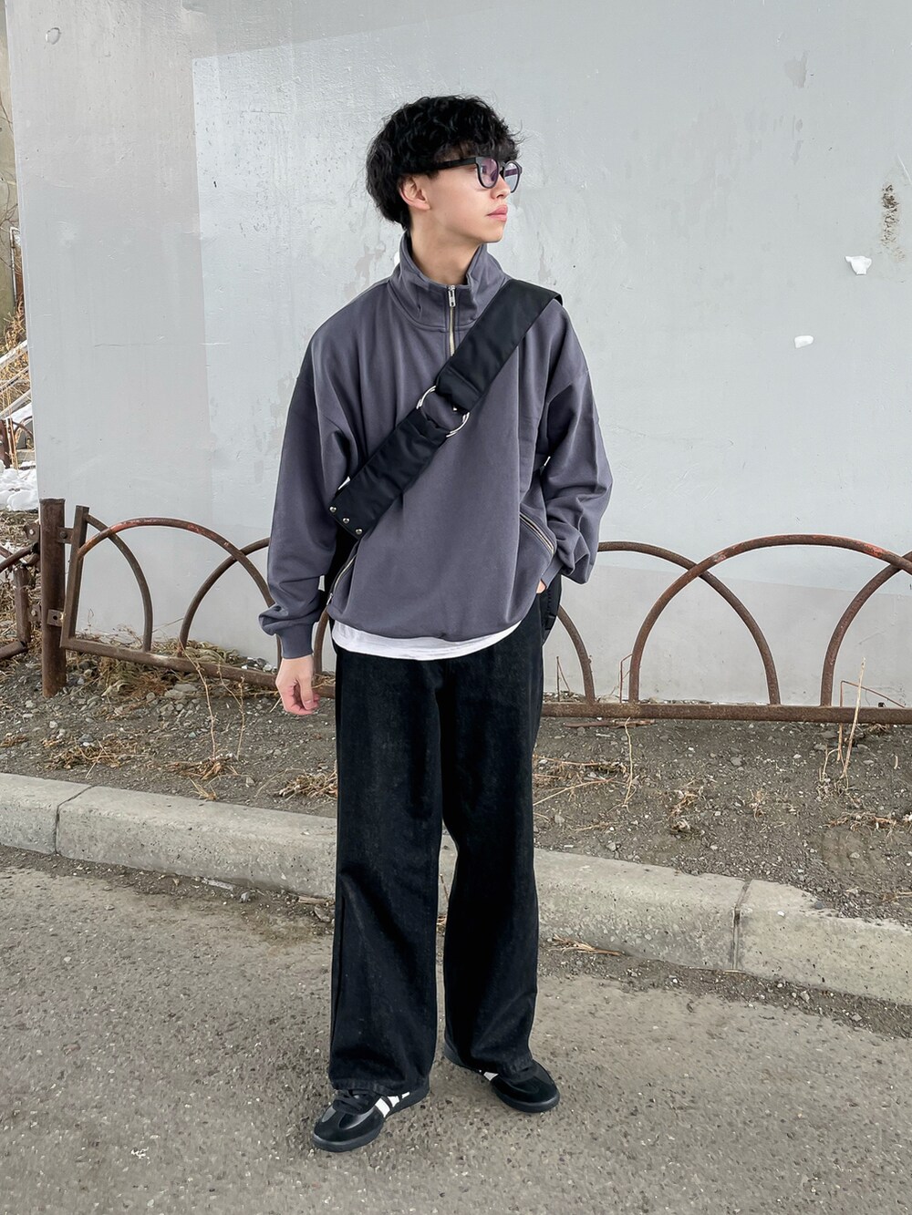 グレー系のスウェット、ブラック系のデニムパンツ、ブラック系のショルダーバッグを着用したメンズの冬コーディネートの3枚目の写真