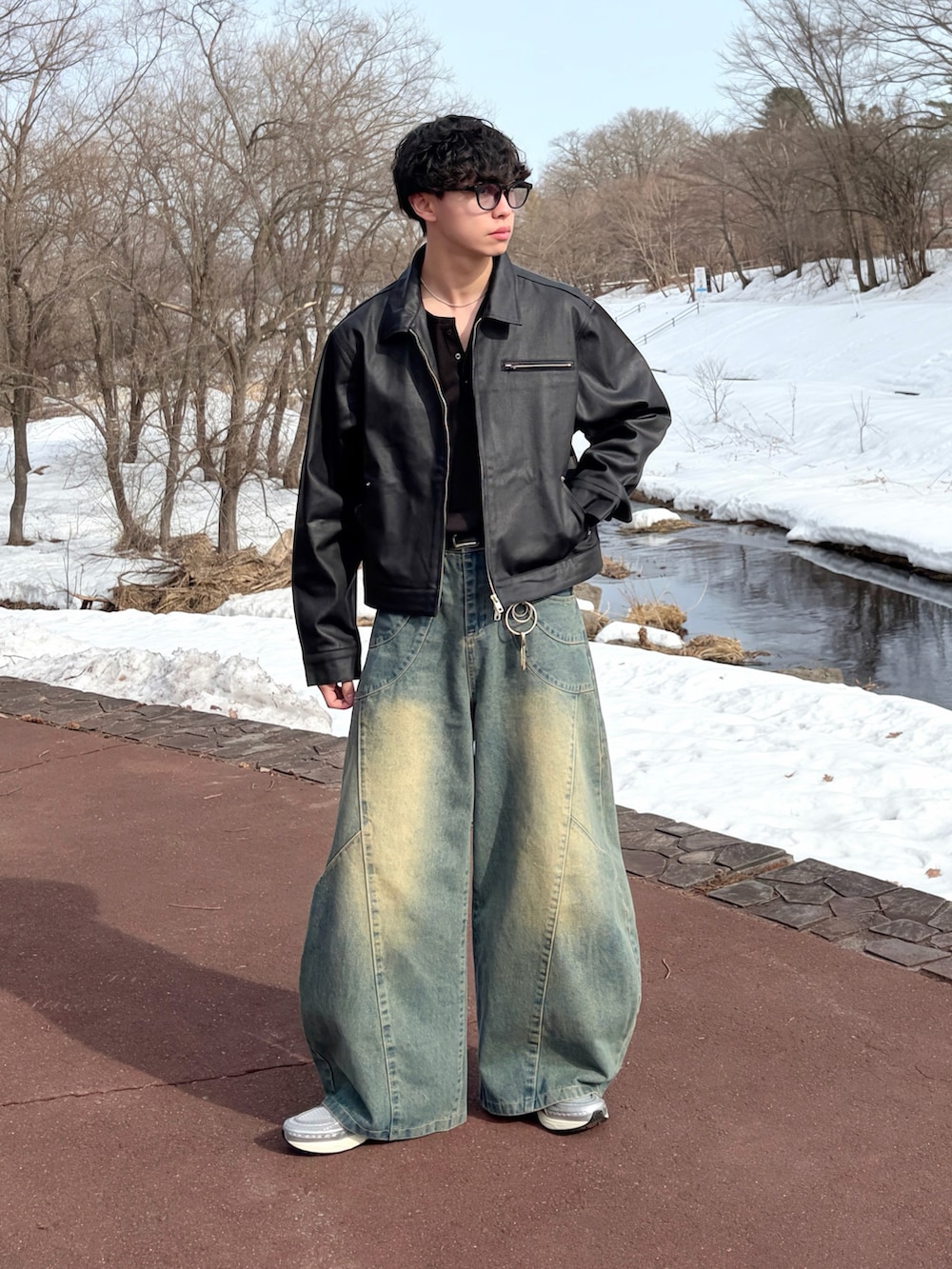 ブルー系のデニムパンツ、ブラック系のTシャツ/カットソー、ブラック系のデニムジャケットを着用したメンズの冬コーディネートの3枚目の写真