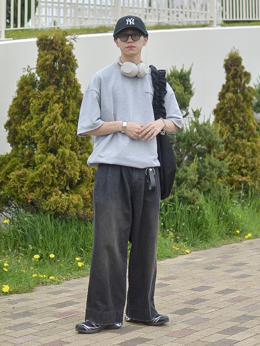 ブラック系のデニムパンツ、グレー系のTシャツ/カットソー、ブラック系のショルダーバッグを着用したメンズの春コーディネートの2枚目の写真
