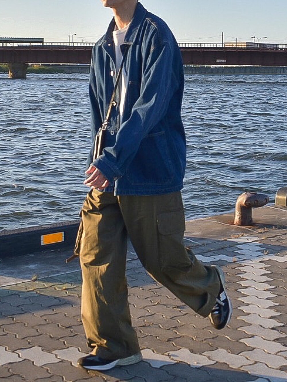 ブルー系のカバーオール、グリーン系のカーゴパンツ、ブラック系のシューズを着用したメンズの秋コーディネートの3枚目の写真