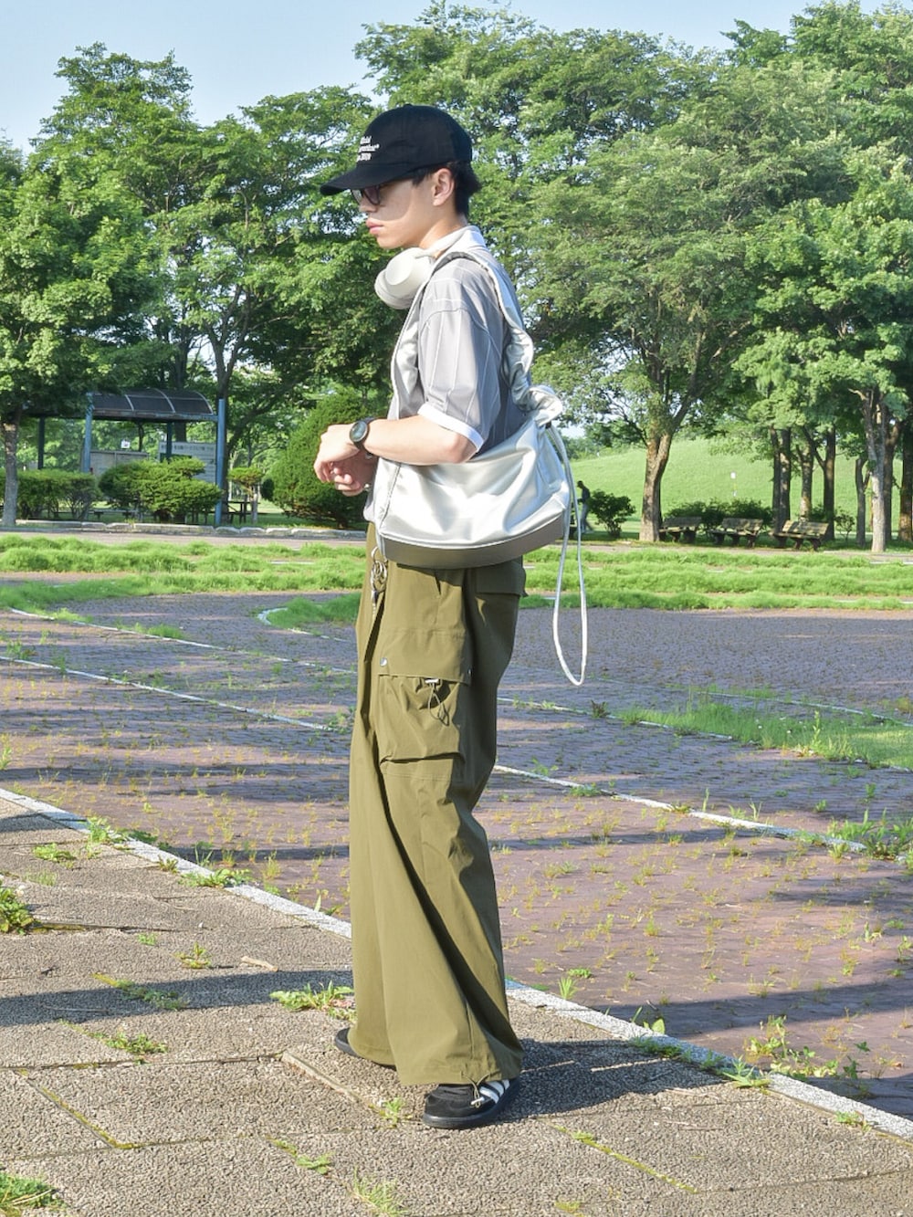 グレー系のTシャツ/カットソー、グリーン系のカーゴパンツ、ブラック系のスニーカーを着用したメンズの夏コーディネートの3枚目の写真