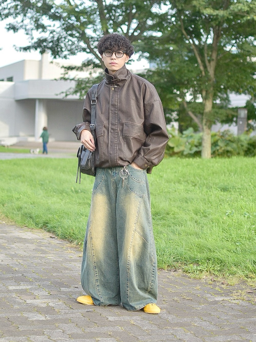 ブラウン系のブルゾン、ブルー系のデニムパンツ、イエロー系のスニーカーを着用したメンズの秋コーディネートの5枚目の写真