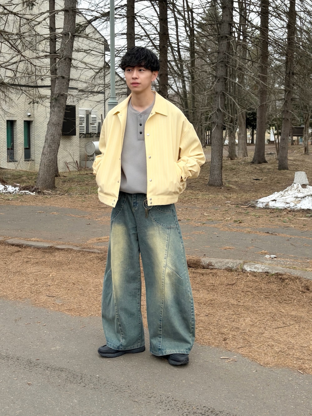 イエロー系のブルゾン、グレー系のTシャツ/カットソー、ブルー系のデニムパンツを着用したメンズの春コーディネートの3枚目の写真