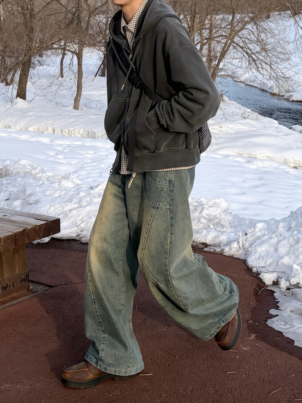 ブルー系のデニムパンツ、グレー系のパーカー、ブラック系のボディバッグ/ウエストポーチを着用したメンズの冬コーディネートの3枚目の写真