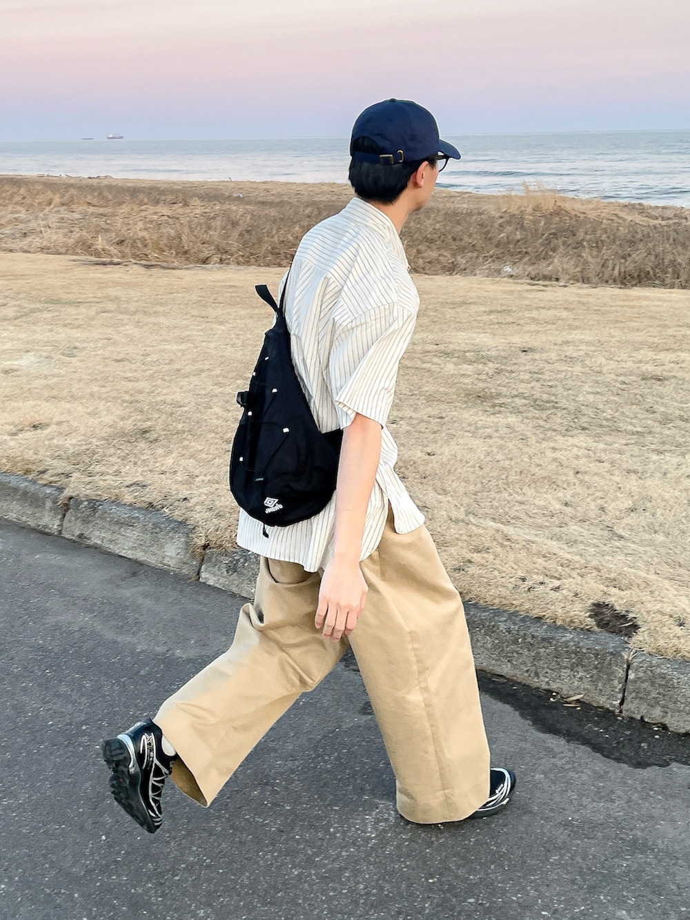 ホワイト系のシャツ/ブラウス、ブラック系のスニーカー、ベージュ系のその他パンツを着用したメンズの春コーディネートの4枚目の写真
