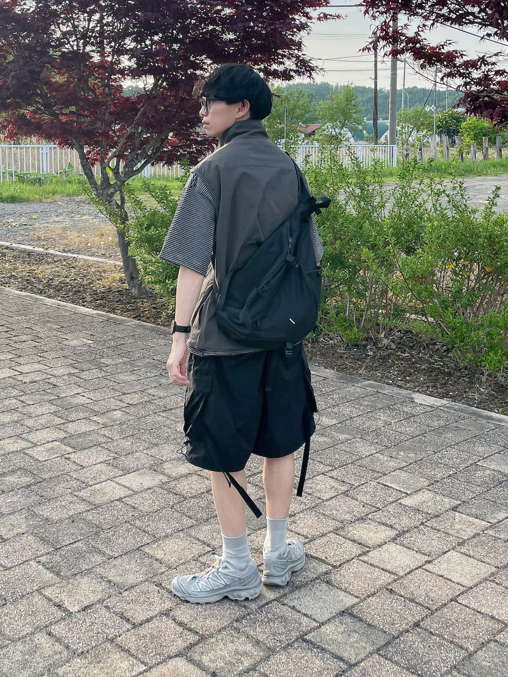 グレー系のベスト、グレー系のTシャツ/カットソー、シルバー系のスニーカーを着用したメンズの春コーディネートの3枚目の写真