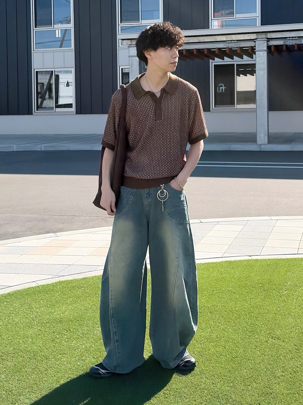 ブラウン系のポロシャツ、ブルー系のデニムパンツ、ブルー系のデニムパンツを着用したメンズの夏コーディネートの2枚目の写真