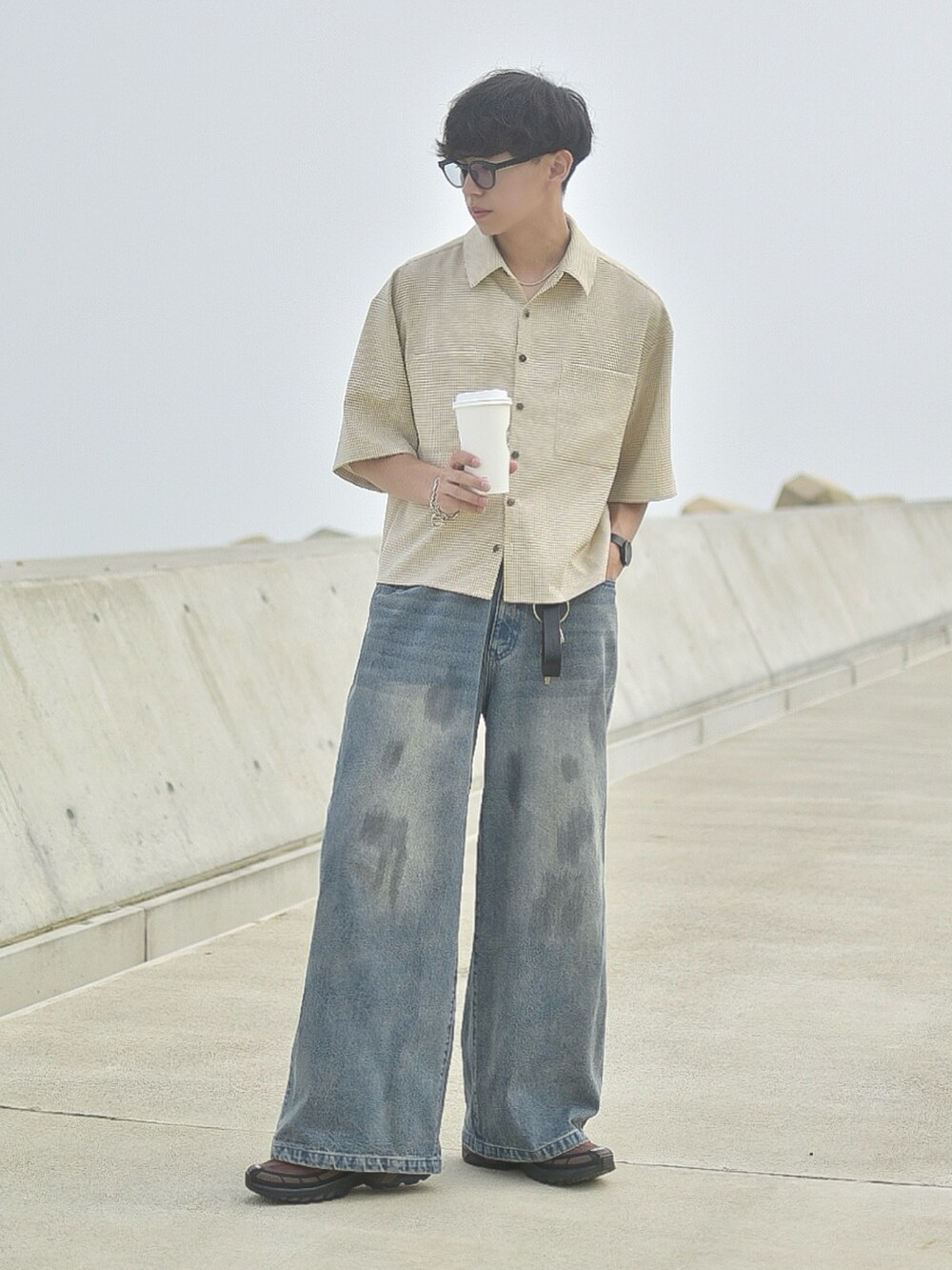 ベージュ系のシャツ/ブラウス、ブルー系のデニムパンツ、ブラウン系のスニーカーを着用したメンズの夏コーディネートの3枚目の写真