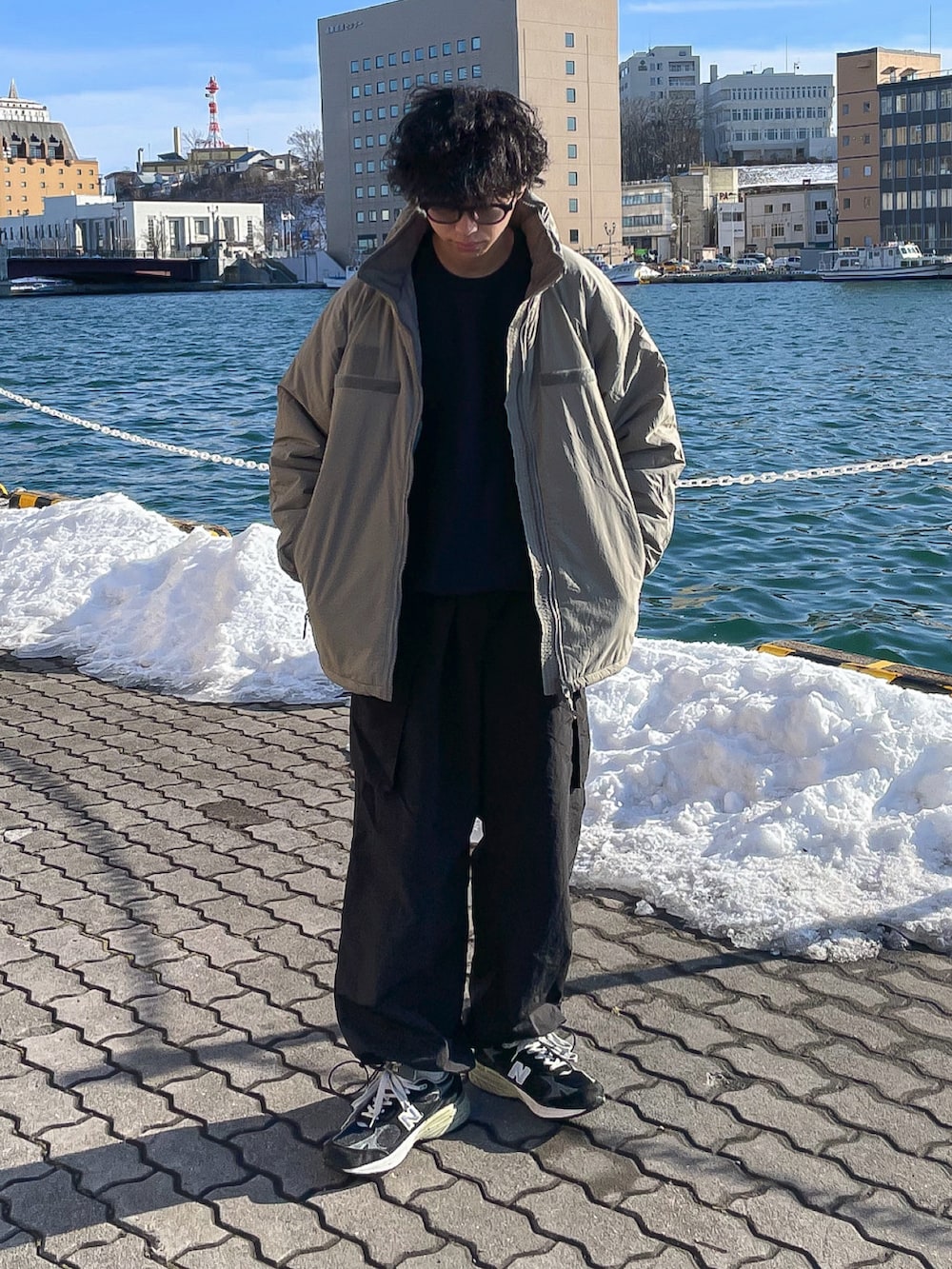 グリーン系のブルゾン、ブルー系のスウェット、ブラック系のカーゴパンツを着用したメンズの冬コーディネートの3枚目の写真