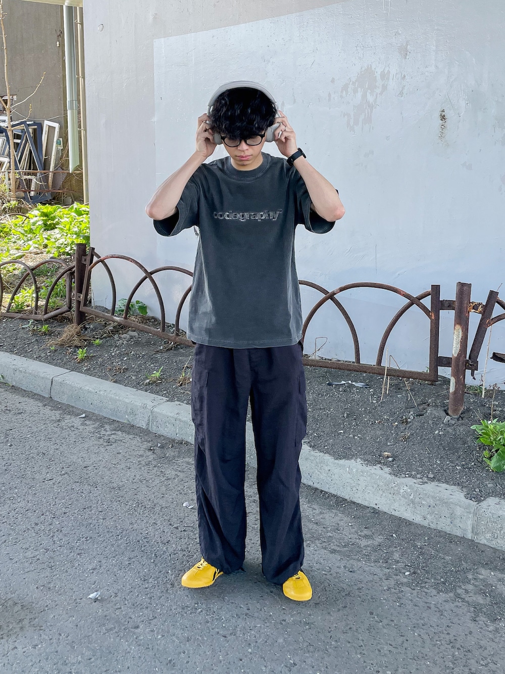 ブラック系のTシャツ/カットソー、ブラック系のカーゴパンツ、イエロー系のスニーカーを着用したメンズの春コーディネートの2枚目の写真