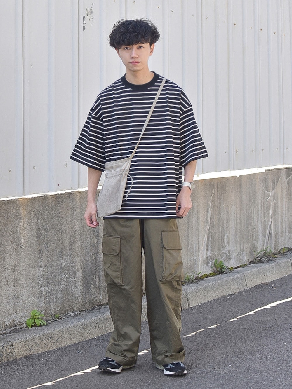 ブラック系のTシャツ/カットソー、グリーン系のカーゴパンツ、ブラック系のシューズを着用したメンズの夏コーディネートの2枚目の写真