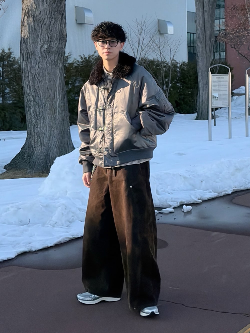 グレー系のブルゾン、ホワイト系のシャツ/ブラウス、ブラウン系のデニムパンツを着用したメンズの冬コーディネートの2枚目の写真