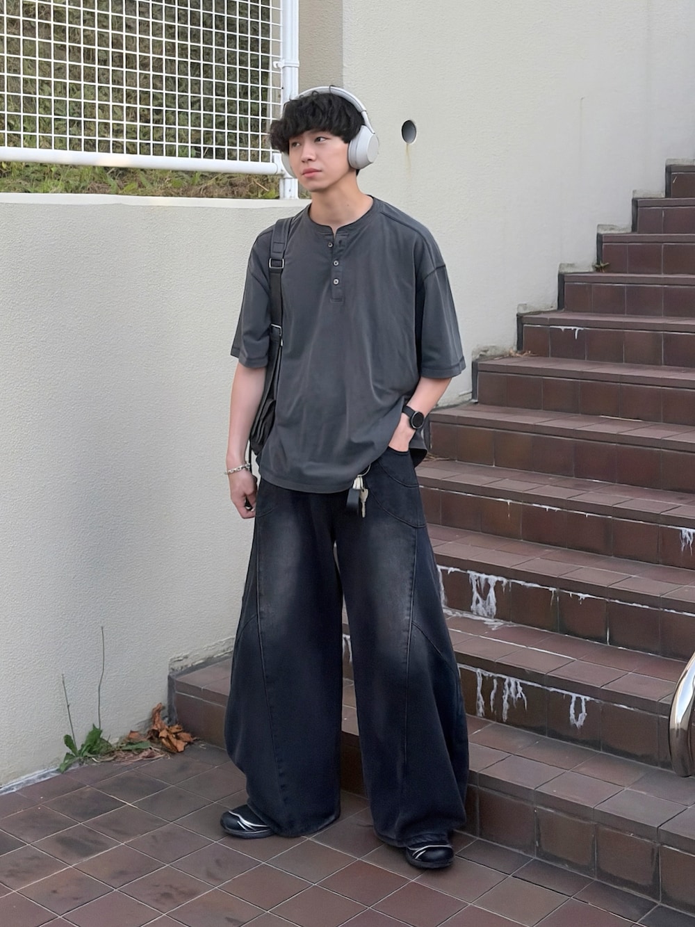 ブラック系のデニムパンツ、ブラック系のTシャツ/カットソー、ブラック系のショルダーバッグを着用したメンズの夏コーディネートの2枚目の写真