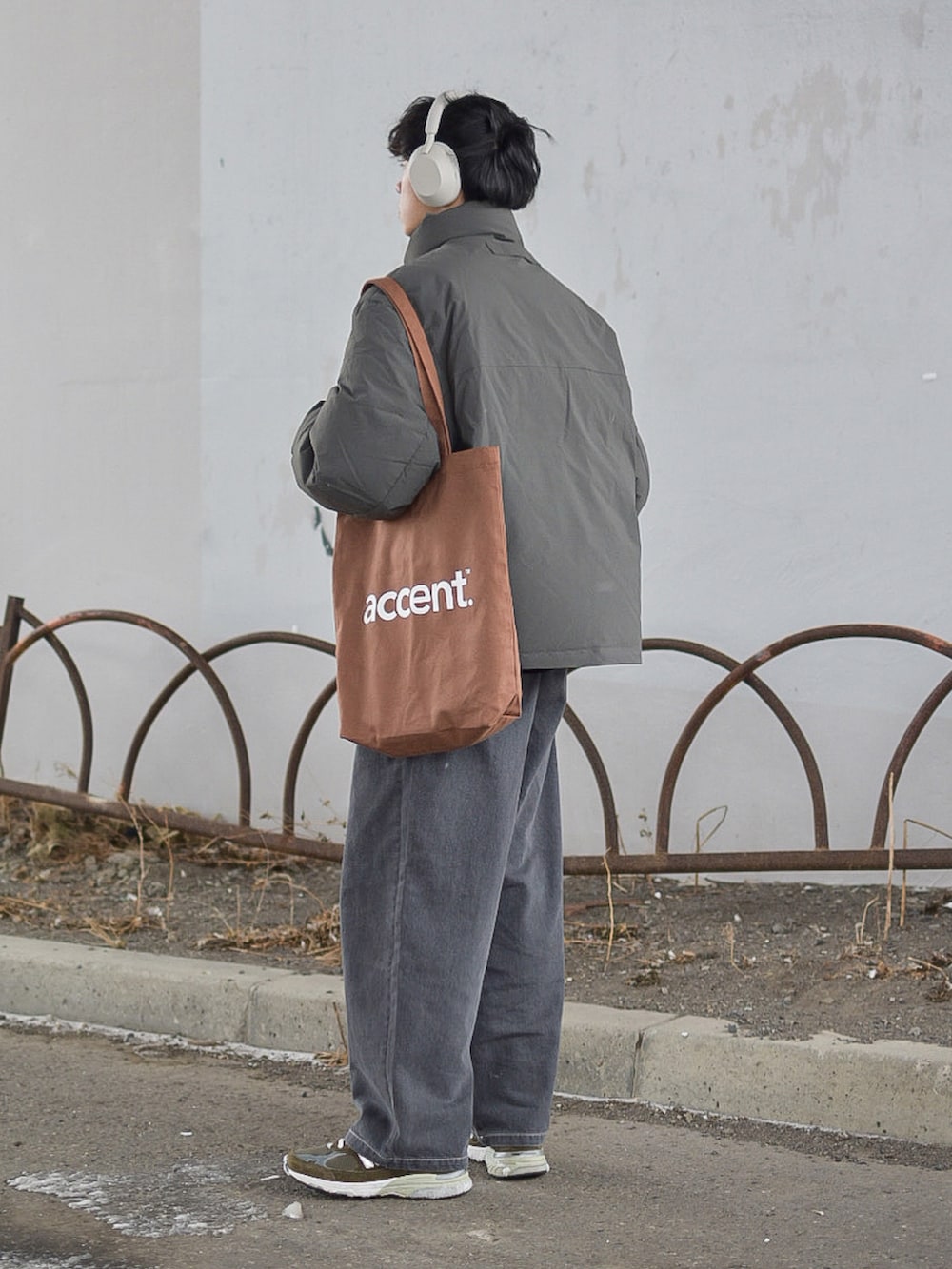 グレー系のジャケット/アウター、グレー系のデニムパンツ、ブラウン系のトートバッグを着用したメンズの冬コーディネートの5枚目の写真