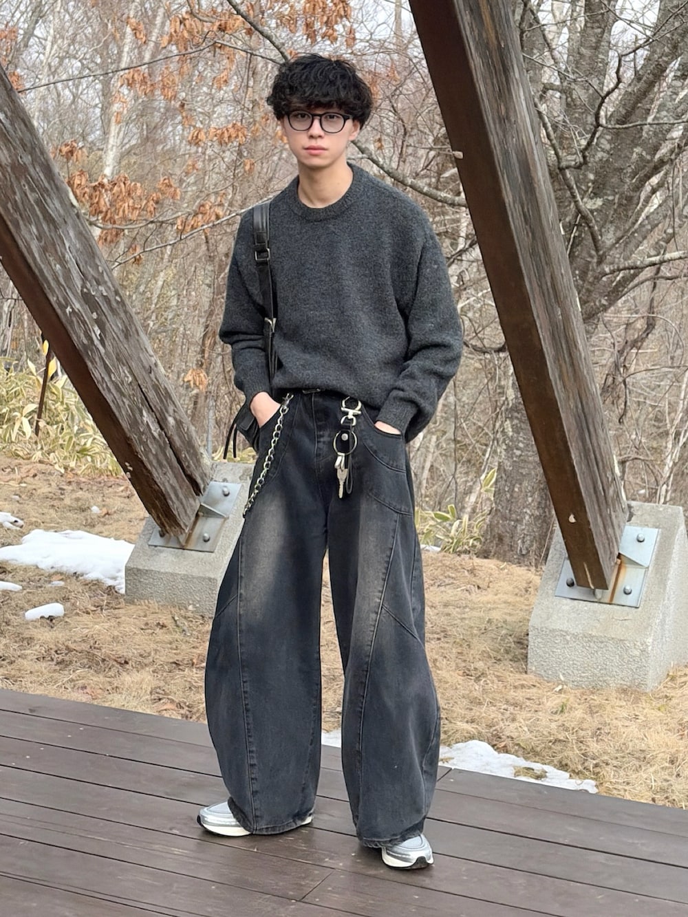 シルバー系のスニーカー、ブラック系のデニムパンツ、ブラウン系のニット/セーターを着用したメンズの冬コーディネートの3枚目の写真