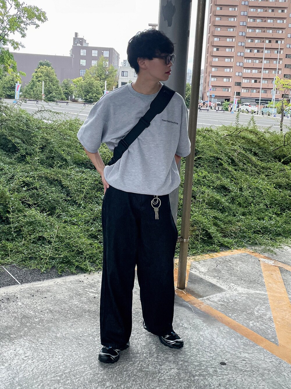 グレー系のTシャツ/カットソー、ブラック系のスニーカー、ブラック系のショルダーバッグを着用したメンズの夏コーディネートの3枚目の写真