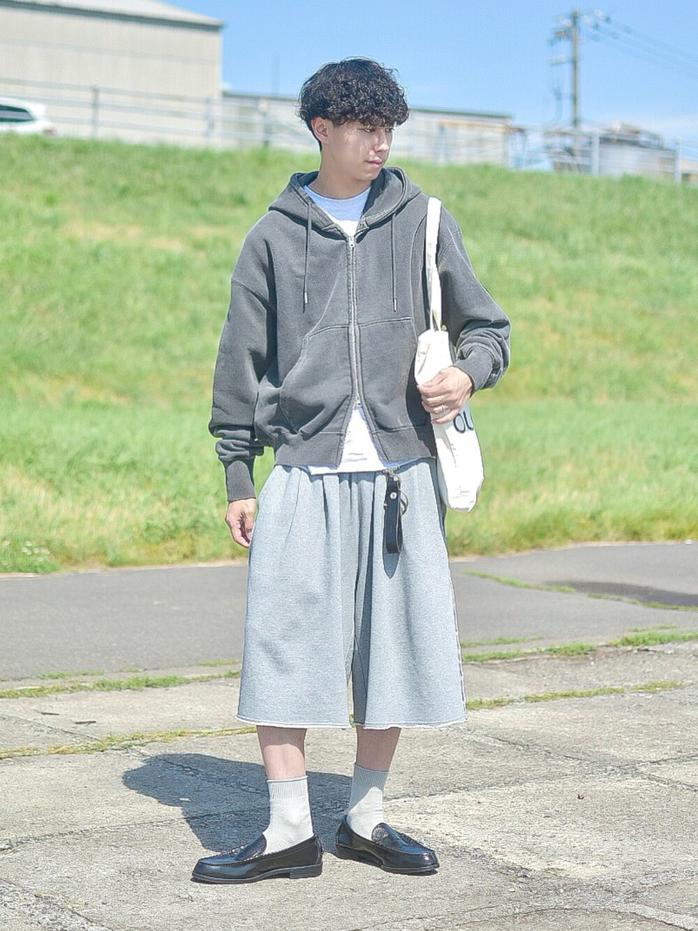 グレー系のパーカー、グレー系のスウェットパンツ、ホワイト系のトートバッグを着用したメンズの夏コーディネートの2枚目の写真