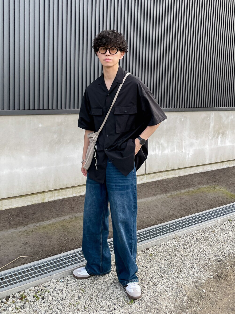 ブラック系のシャツ/ブラウス、ブルー系のデニムパンツ、ホワイト系のスニーカーを着用したメンズの夏コーディネートの2枚目の写真