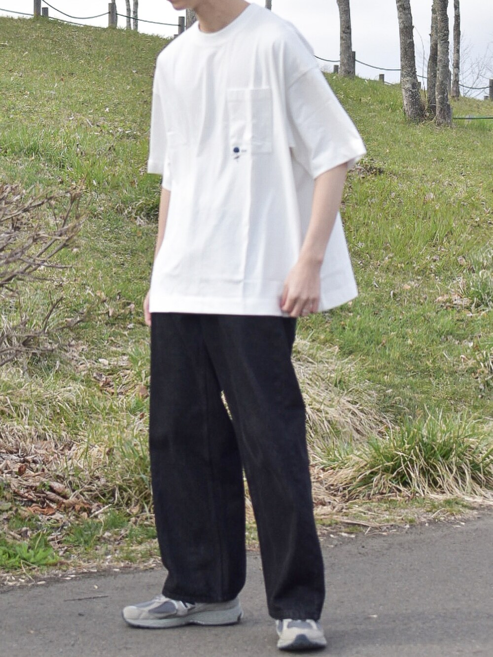 グレー系のニット/セーター、ホワイト系のTシャツ/カットソー、ブラック系のデニムパンツを着用したメンズの春コーディネートの4枚目の写真