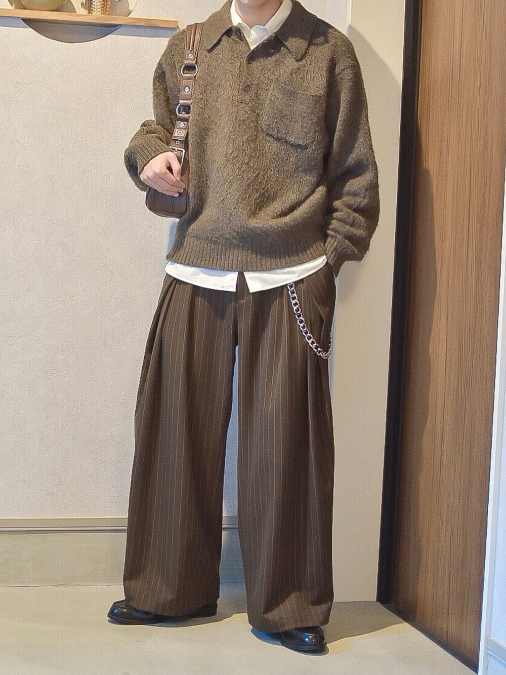 ブラウン系のポロシャツ、ホワイト系のシャツ/ブラウス、ブラウン系のスラックスを着用したメンズの秋コーディネートの3枚目の写真