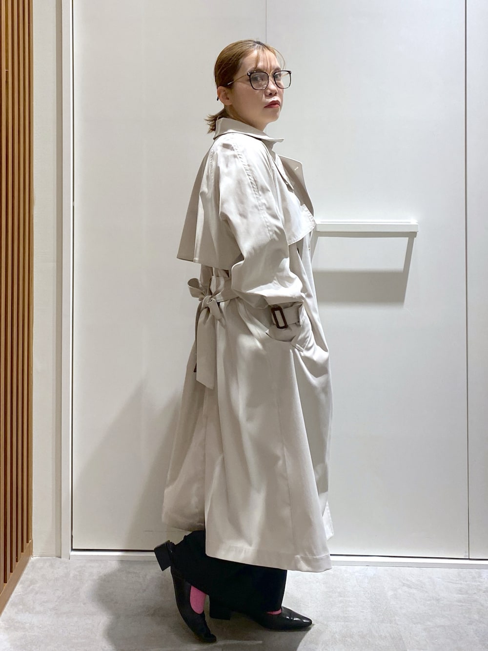 ホワイト系のTシャツ/カットソー、ホワイト系のトレンチコート、ブラック系のショルダーバッグを着用したレディースの春コーディネートの4枚目の写真