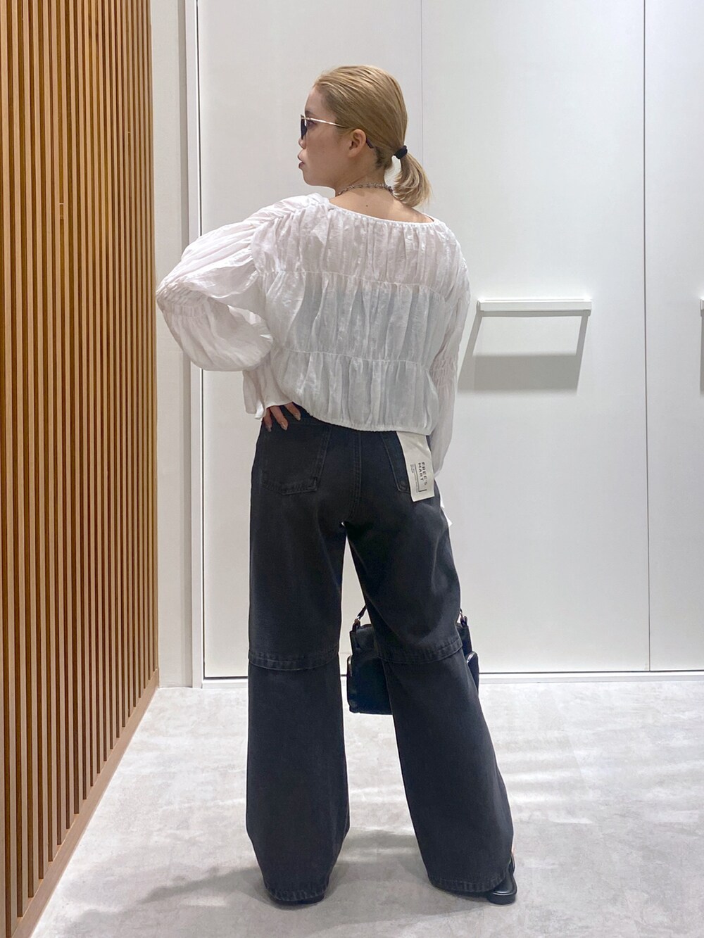 ホワイト系のシャツ/ブラウス、ブラック系のデニムパンツ、ブラック系のショルダーバッグを着用したレディースの春コーディネートの3枚目の写真