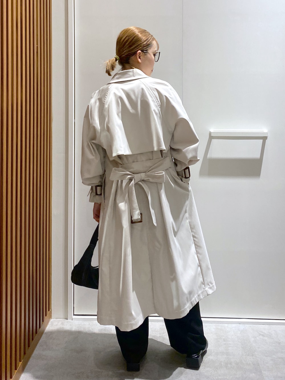 ホワイト系のTシャツ/カットソー、ホワイト系のトレンチコート、ブラック系のショルダーバッグを着用したレディースの春コーディネートの3枚目の写真