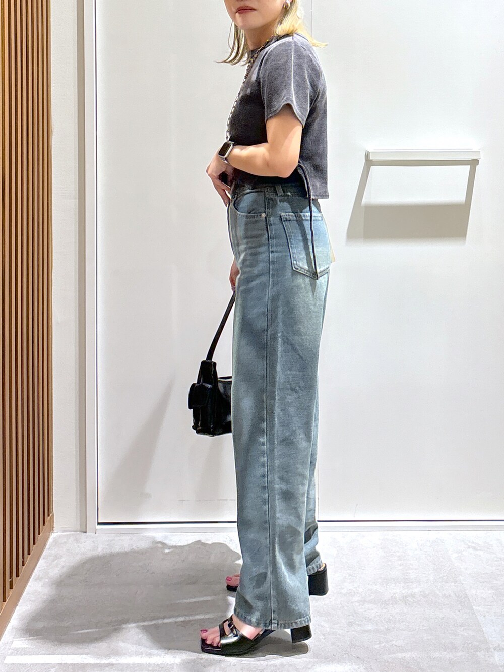 ブラック系のTシャツ/カットソー、ブルー系のデニムパンツ、ブラック系のハンドバッグを着用したレディースの秋コーディネートの3枚目の写真