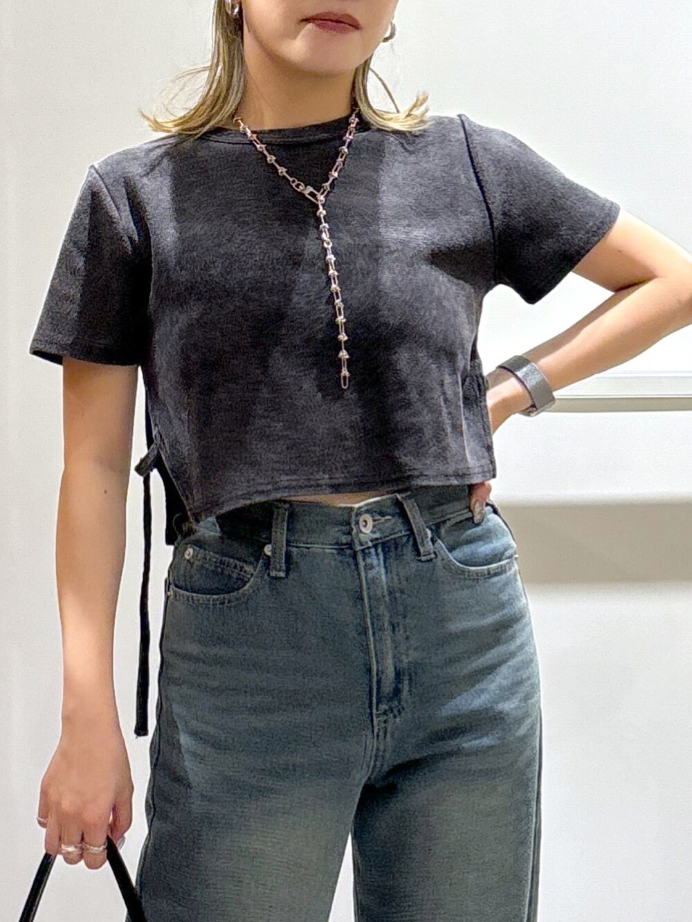 ブラック系のTシャツ/カットソー、ブルー系のデニムパンツ、ブラック系のハンドバッグを着用したレディースの秋コーディネートの4枚目の写真