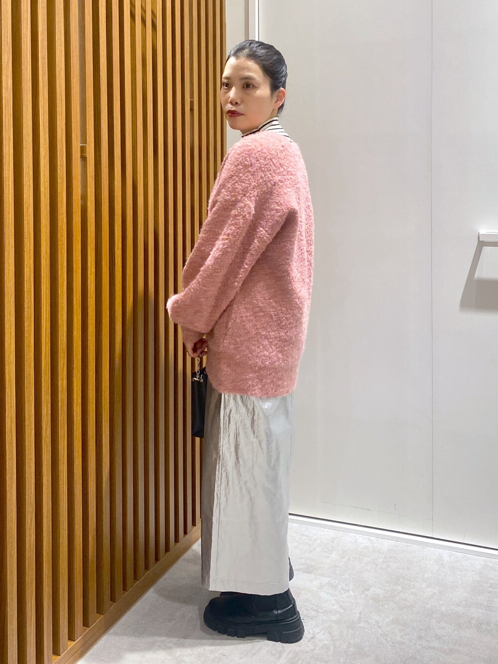 ホワイト系のニット/セーター、パープル系のカーディガン/ボレロ、ブラック系のショルダーバッグを着用したレディースの冬コーディネートの2枚目の写真