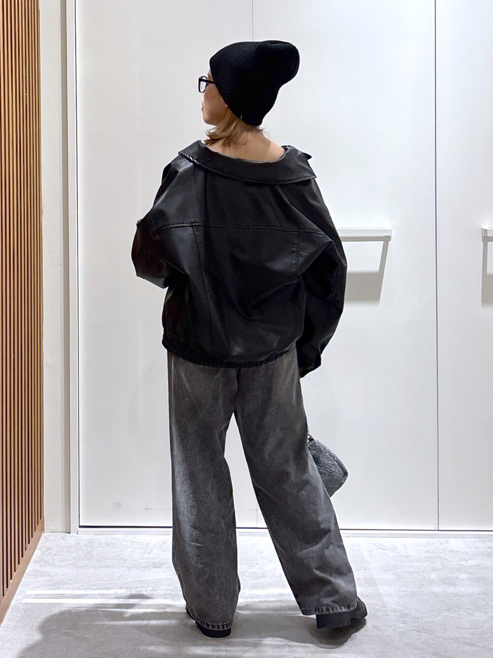 ブラック系のキャミソール、ブラック系のライダースジャケット、ブラック系のデニムパンツを着用したレディースの秋コーディネートの2枚目の写真