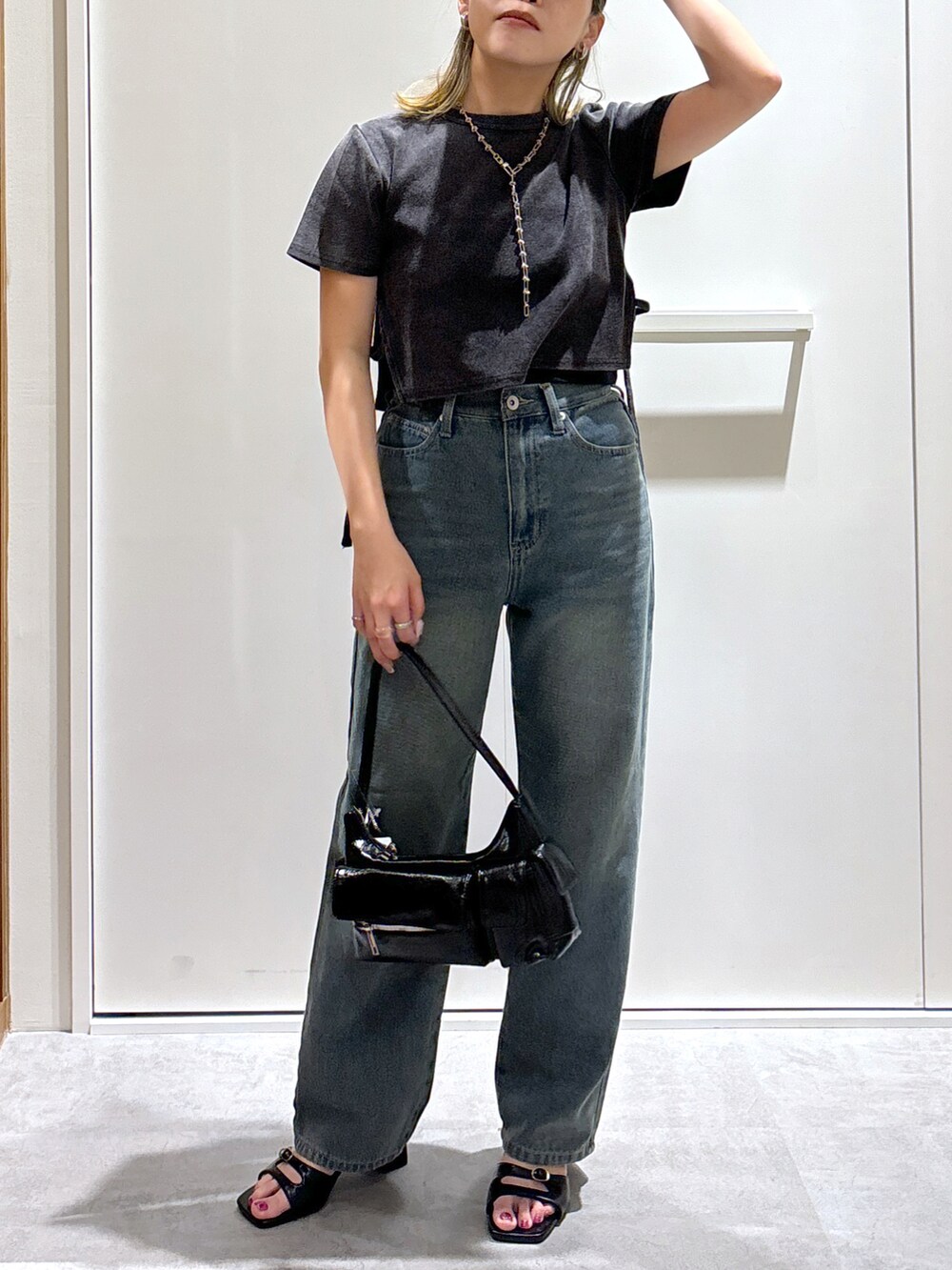 ブラック系のTシャツ/カットソー、ブルー系のデニムパンツ、ブラック系のハンドバッグを着用したレディースの秋コーディネートの5枚目の写真