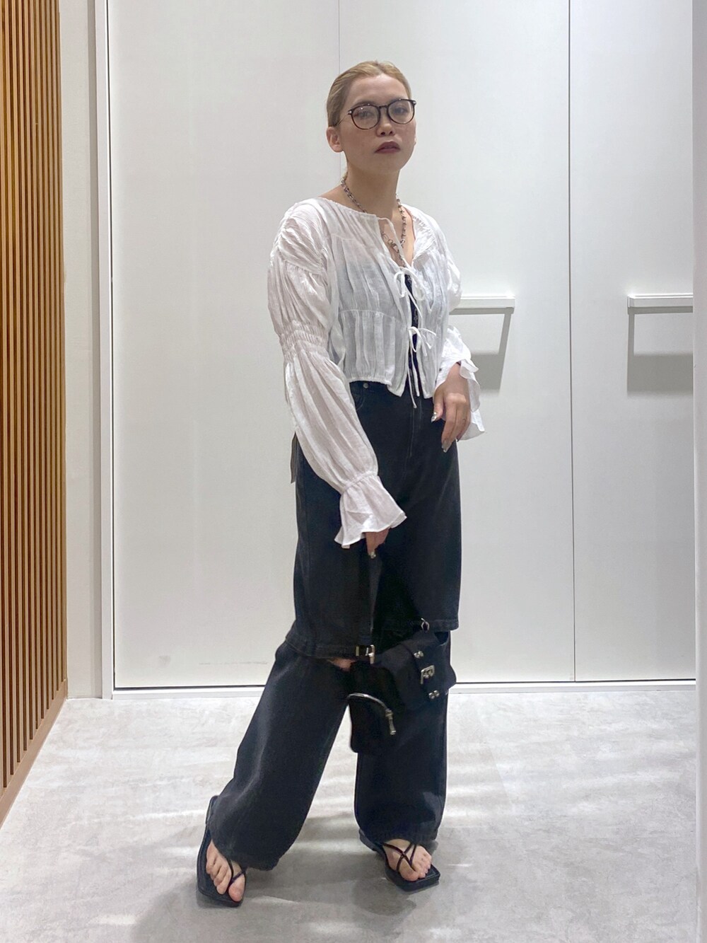 ホワイト系のシャツ/ブラウス、ブラック系のデニムパンツ、ブラック系のショルダーバッグを着用したレディースの春コーディネートの2枚目の写真