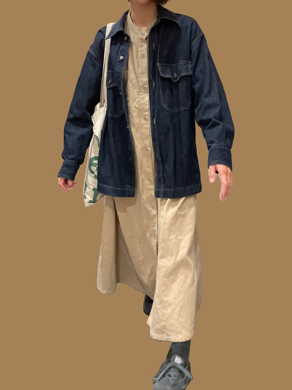 ベージュ系のワンピース、ブラック系のスニーカーを着用したレディースの秋コーディネートの3枚目の写真