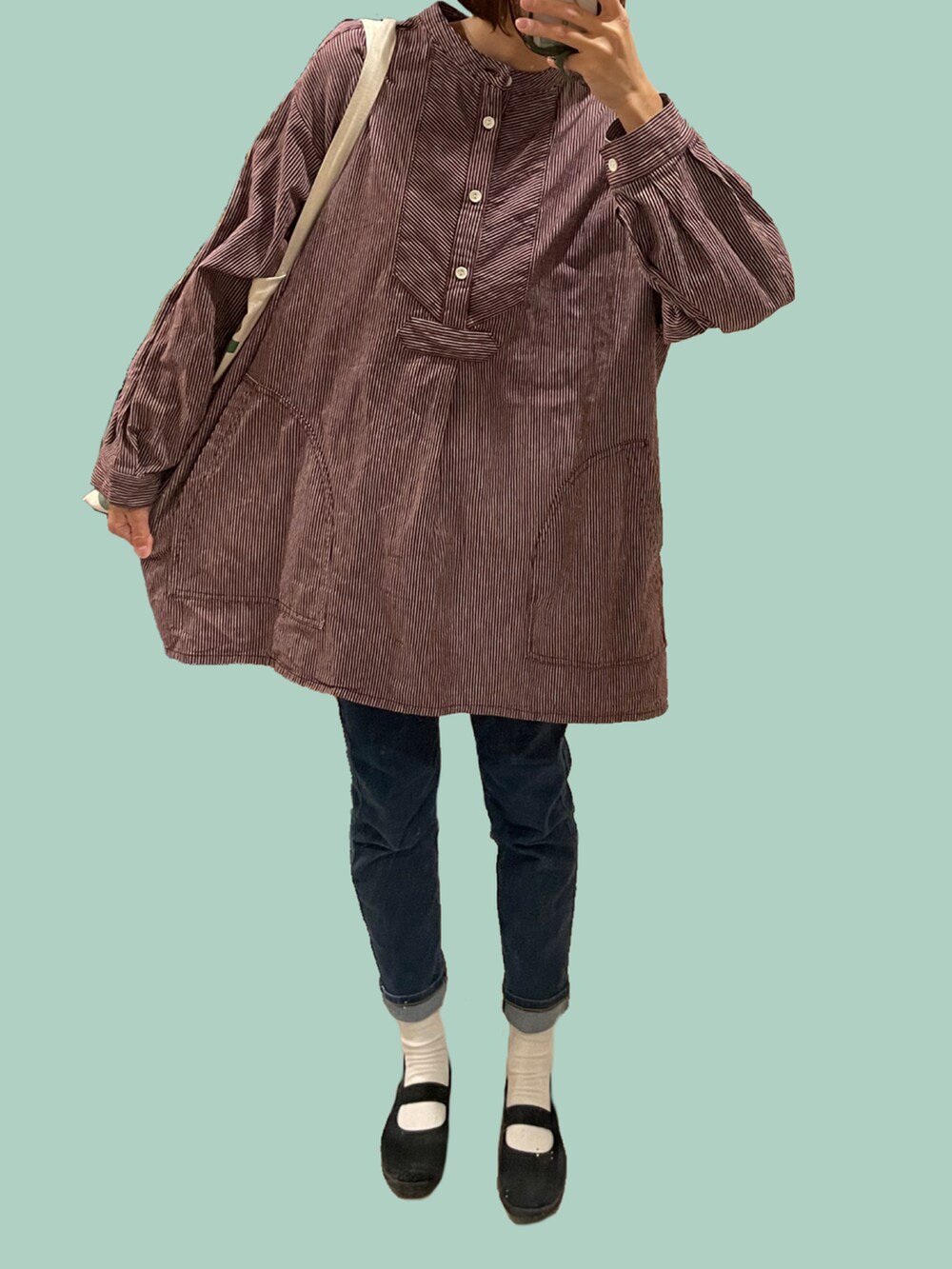 ブラック系のスニーカー、ブラウン系のその他アウター、ブルー系のデニムパンツを着用したレディースの冬コーディネートの2枚目の写真