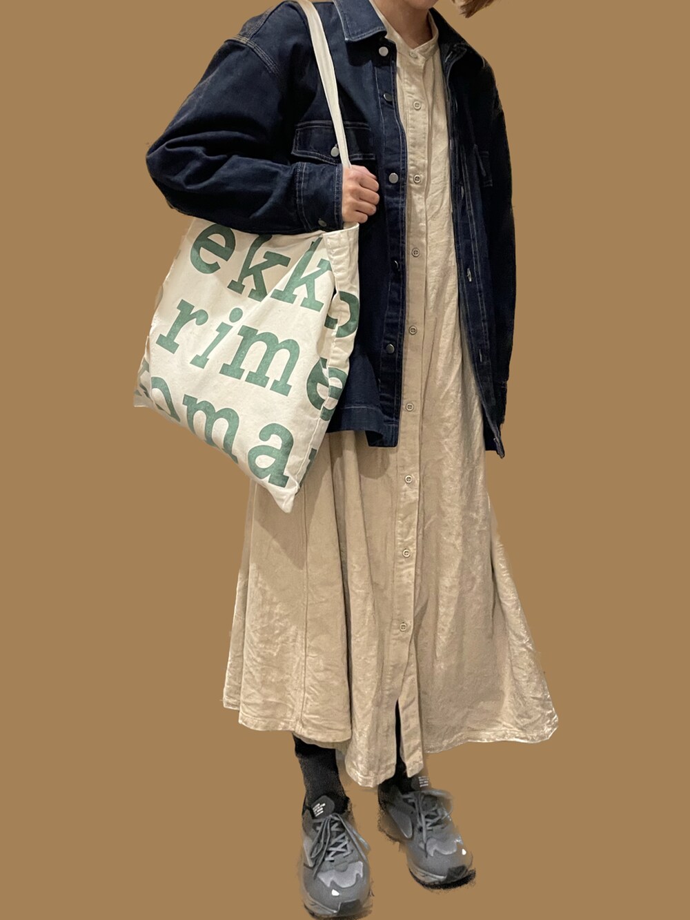 ベージュ系のワンピース、ブラック系のスニーカーを着用したレディースの秋コーディネートの2枚目の写真