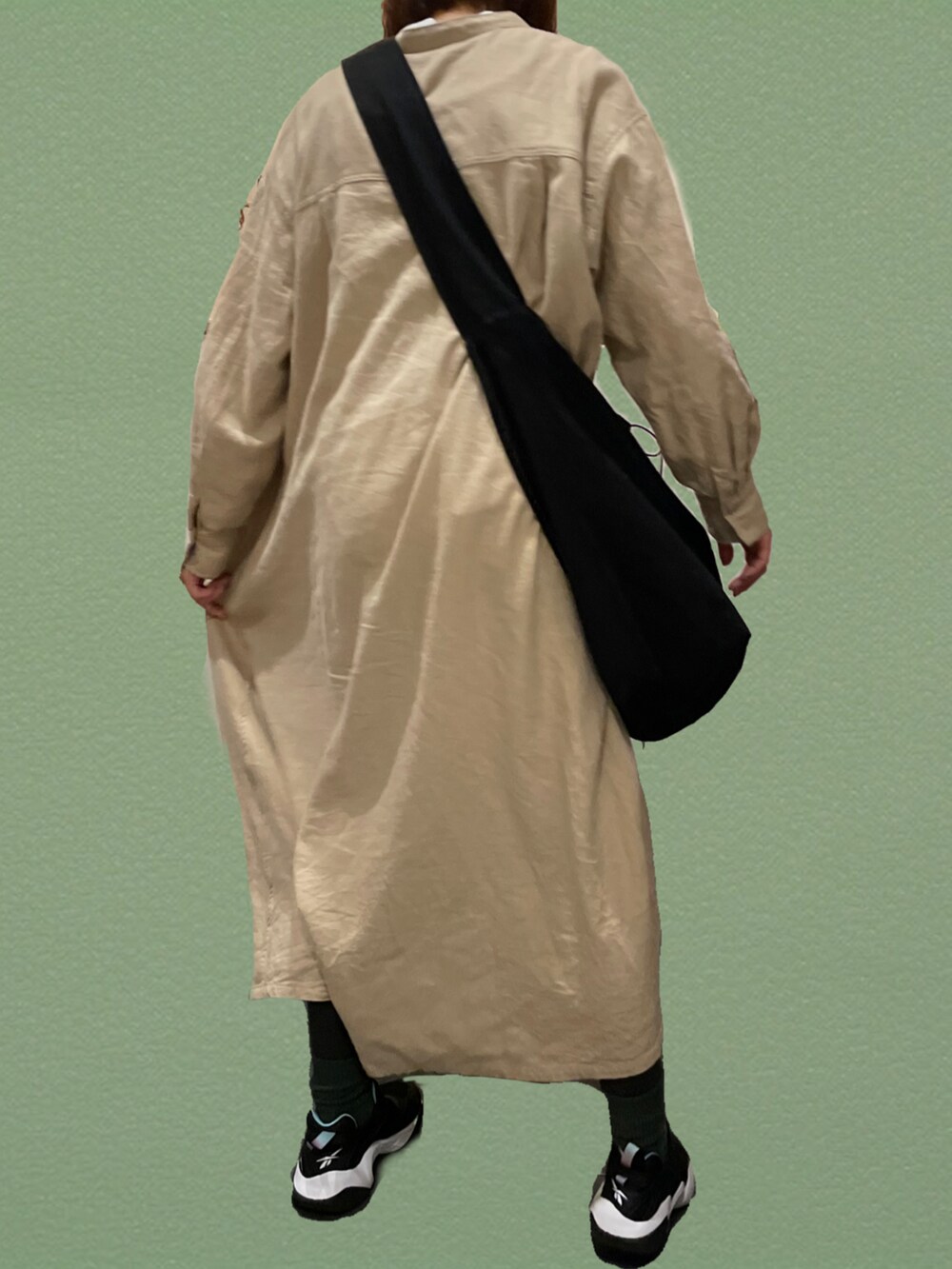 ブラック系のショルダーバッグ、ベージュ系のワンピース、ブラック系のスニーカーを着用したレディースの秋コーディネートの3枚目の写真