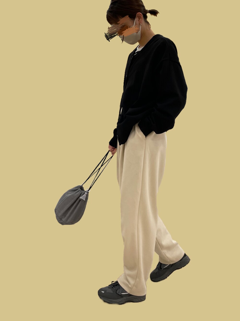 ブラック系のカーディガン/ボレロ、ベージュ系のパンツ、ブラック系のスニーカーを着用したレディースの秋コーディネートの3枚目の写真
